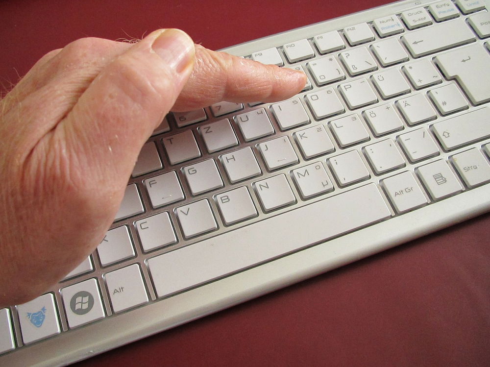 Person pressing a key on a keyboard